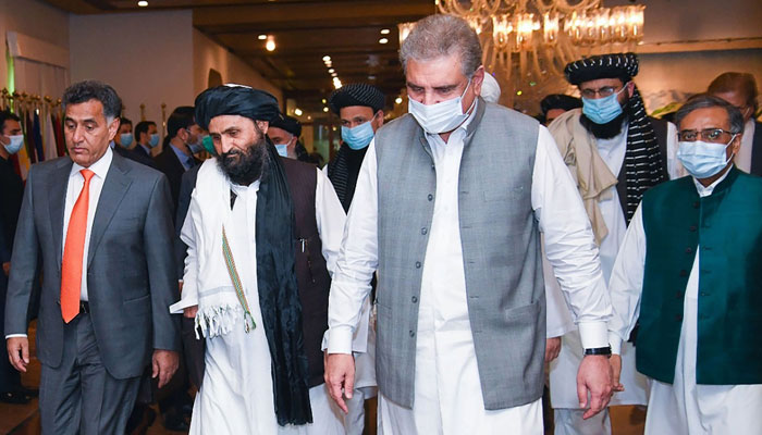 Foreign Minister Shah Mahmood Qureshi walks with Taliban co-founder Mullah Abdul Ghani Baradar. Photo: file