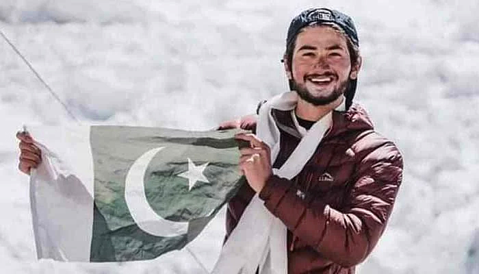 Shehroze Kashif waves the Pakistani flag after completing his expedition. — Alpine Adventure Guides