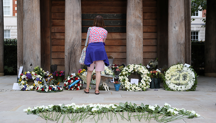 A woman stands next to flowers during a memorial service on the anniversary of the 9/11 attack, in London, Britain September 11, 2021. — Reuters