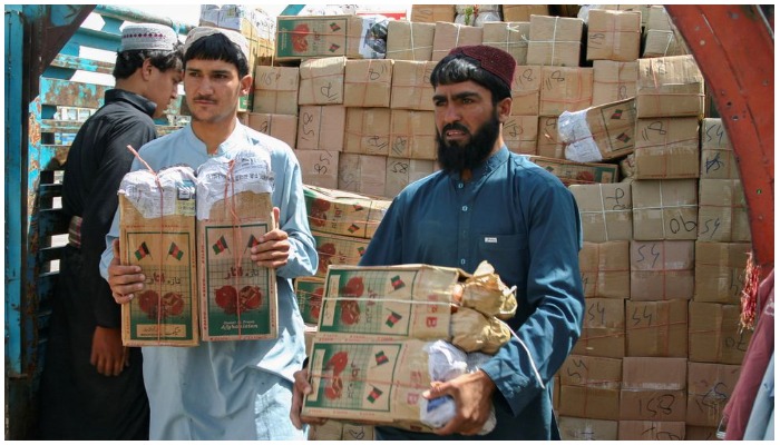 Labourers unload boxes of pomegranates from Afghanistan, from a truck at the Friendship Gate crossing point, in the Pakistan-Afghanistan border town of Chaman, Pakistan, September 7, 2021. REUTERS