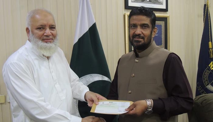 Director-General NAB Lahore Shahzad Saleem (right) handing over Rs11.64 million cheque to NBP official. — NAB handout