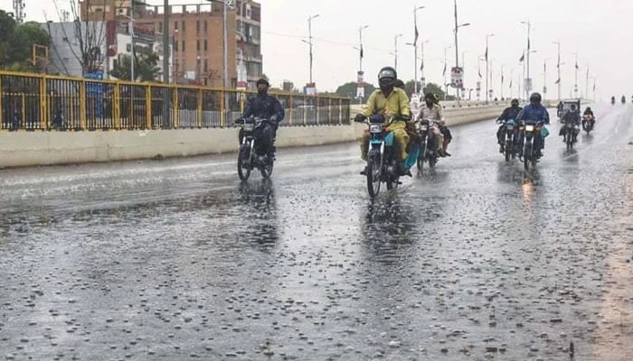 Motorcyclists can be seen on the roads of Karachi as the city received light rain on Wednesday. — Geo News/File