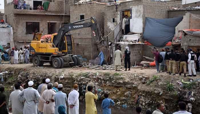 Karachi Development Authority (KDA) staffers demolishing the illegal constructions during anti-encroachment operation on the Gujar Nullah at Gulbarg area. Photo: online