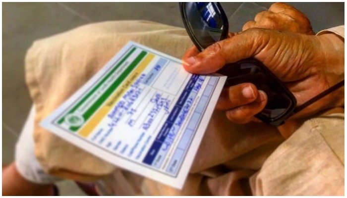 A citizen holds his vaccination card. Photo Geo.tv