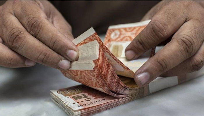 A currency dealer is counting Rs5,000 notes. — AFP/File