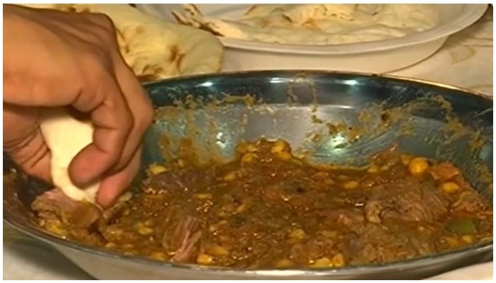 Man-eating a chickpea and ostrich meat curry with naan. Photo: Reuters