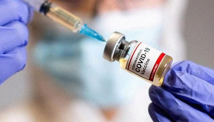 A woman holds a small vial — labelled Coronavirus COVID-19 Vaccine — and a medical syringe, October 30, 2020. Photo: Reuters
