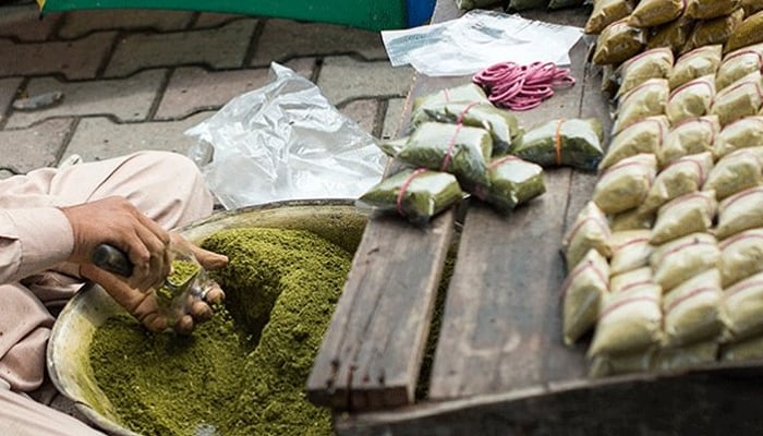 A man making naswar, which is a form of smokeless tobacco. — Twitter/File