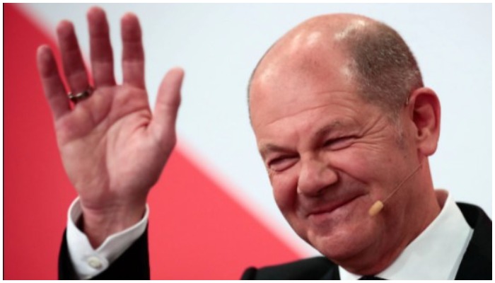 Social Democratic Party (SPD) leader and a top candidate for chancellor Olaf Scholz waves after first exit polls for the general elections in Berlin, Germany, September 26, 2021. REUTERS/Hannibal Hanschke