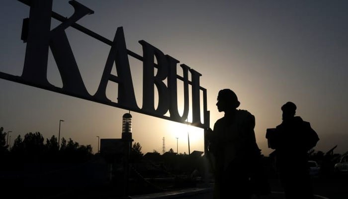 Taliban soldiers stand in front of a sign at the international airport in Kabul, Afghanistan, September 9, 2021. WANA (West Asia News Agency) via REUTERS