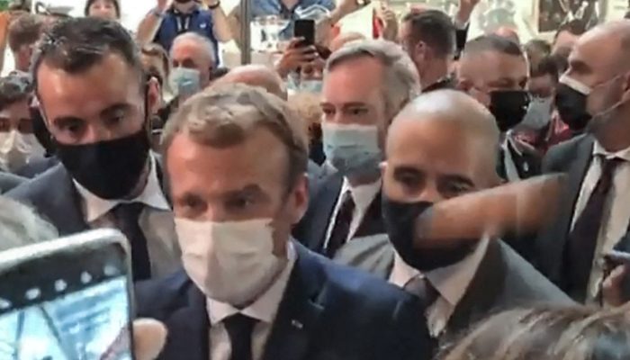 This video grab made from a footage by LyonMag.com shows an egg bouncing on French President Emmanuel Macron´s shoulder — AFP