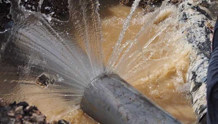 Water flowing with great pressure following a pipeline burst. — Shutterstock image