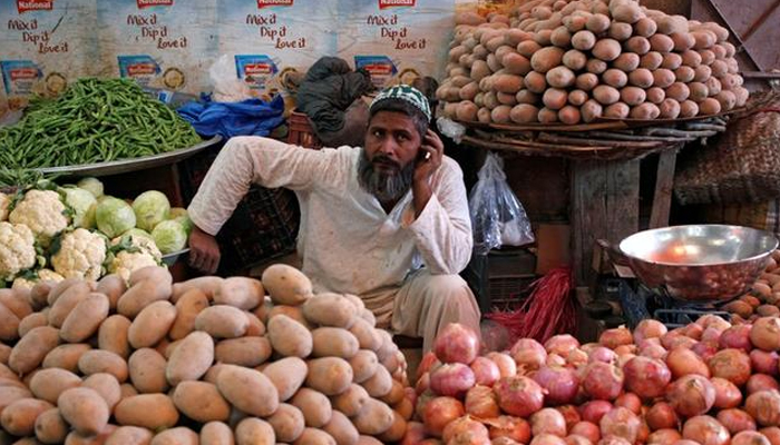 A vendor can be seen selling fresh vegetables. — AFP/File