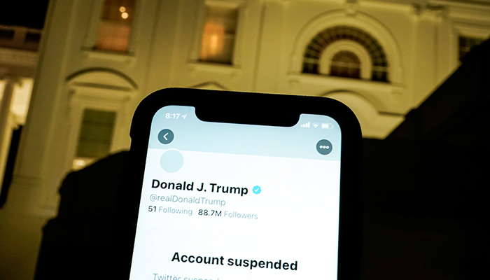 A photo illustration shows the suspended Twitter account of US President Donald Trump on a smartphone and the White House in Washington, US, January 8, 2021. — Reuters/File