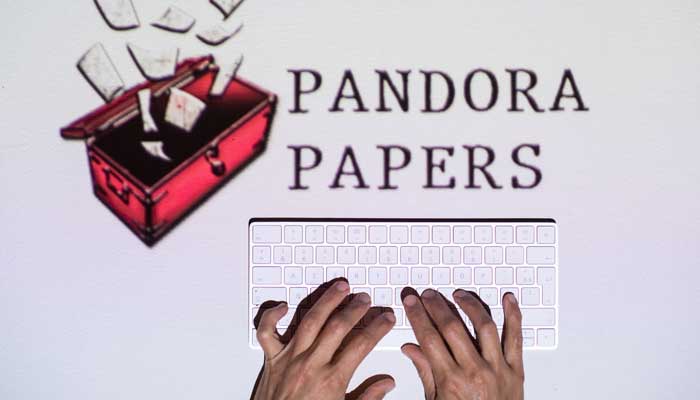 This photograph illustration shows hands typing on a keyboard in front of the logo of Pandora Papers, in Lavau-sur-Loire, western France, on October 4, 2021. — AFP