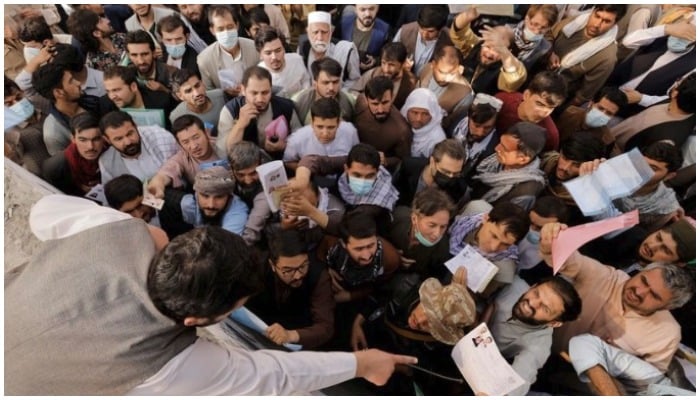 Afghans gather outside the passport office after Taliban officials announced they will start issuing passports to its citizens again, following months of delays that hampered attempts by those trying to flee the country after the Taliban seized control, in Kabul, Afghanistan October 6, 2021. REUTERS/Jorge Silva