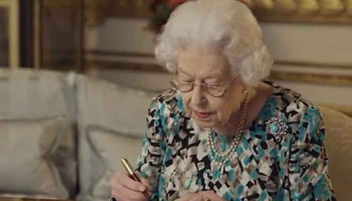 The Queen signs her message to be read at the Commonwealth games