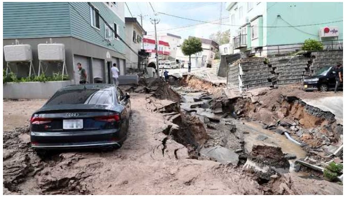 A car is seen stuck on a road damaged by an earthquake in Japan. Photo: AFP