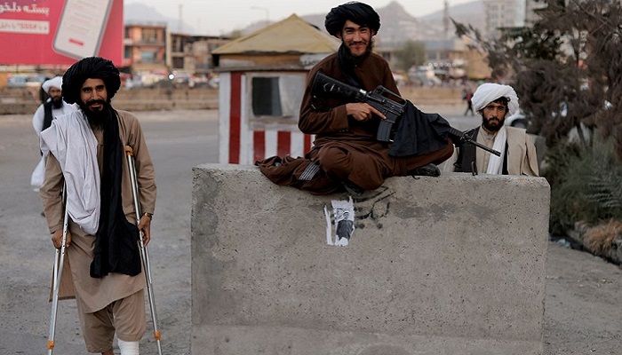 Taliban fighter Mira Jan Himmat, 30, and Rafiullah, 26, from Helmand province smile as they stand guard in a checkpoint in Kabul, Afghanistan October 5, 2021. Photo: Reuters