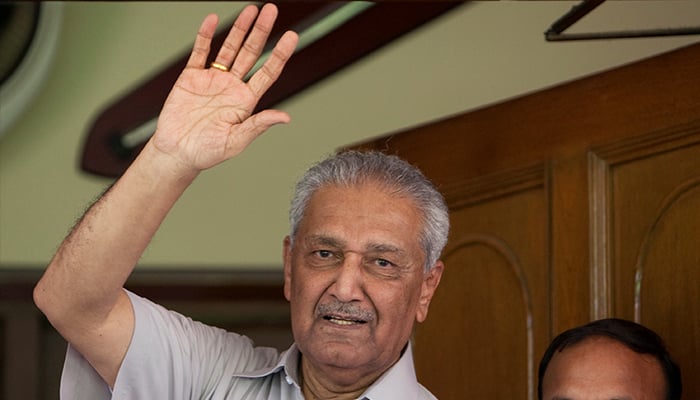 Pakistan nuclear scientist Abdul Qadeer Khan waves to journalists from the front door of his house in Islamabad on August 28, 2009. — Reuters