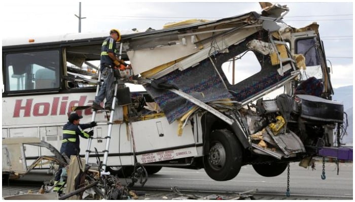 Workers cut away debris from the front of a bus involved in a mass casualty crash on the westbound Interstate 10 freeway near Palm Springs, California October 23, 2016. PHOTO: REUTERS