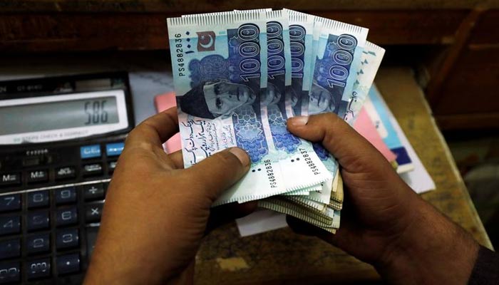 A trader counts Pakistani rupee notes at a currency exchange booth in Peshawar, Pakistan December 3, 2018. — Reuters/File