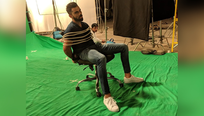 Indian skipper Virat Kohli can be seen tied to a chair in this undated photo. — Twitter/imVkohli