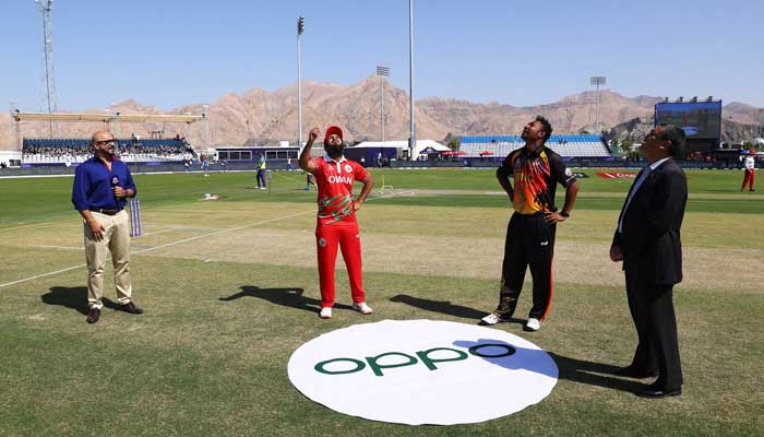 Oman skipper Zeeshan Maqsood (2nd L) tosses the coin in the air, in the opening match of the Twenty20 World Cup, at the Al Amerat ground in Dubai, on October 17, 2021. — Photo courtesy ICC