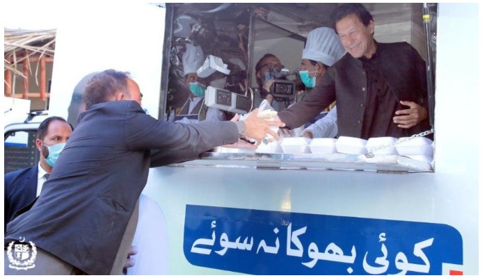 Prime Minister Imran Khan handing over a parcel of meal to a man from a mobile food truck. Photo — Poverty Alleviation and Safety Division