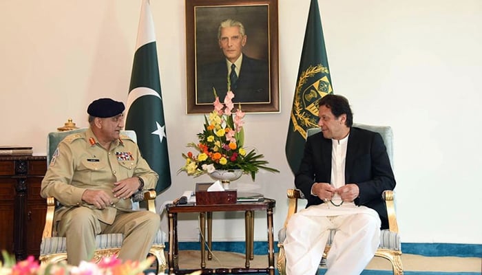 Chief of Army Staff General Qamar Javed Bajwa (L) talking to Prime Minister Imran Khan (R) —PID/File