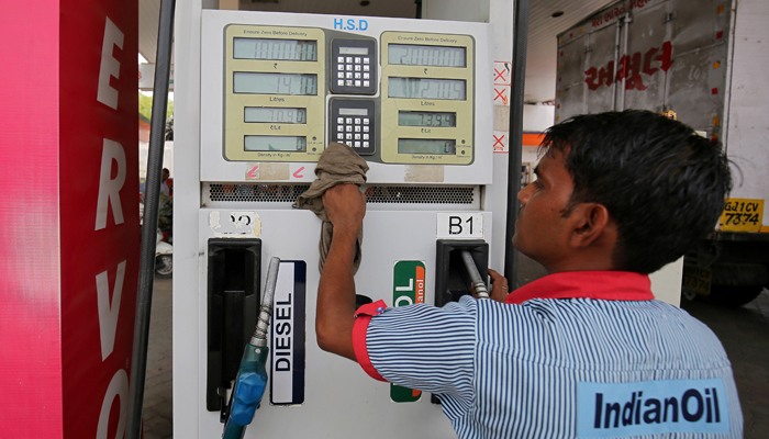 A fuel pump attendant cleans the keypad of a pump at an Indian Oil filling station in Ahmedabad, India, May 14, 2018. — Reuters/File