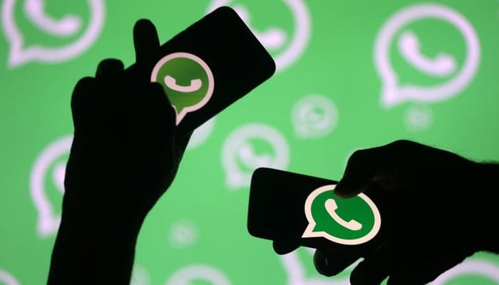 People pose with smartphones in front of the displayed Whatsapp logo in this illustration on September 14, 2017. — Reuters/File