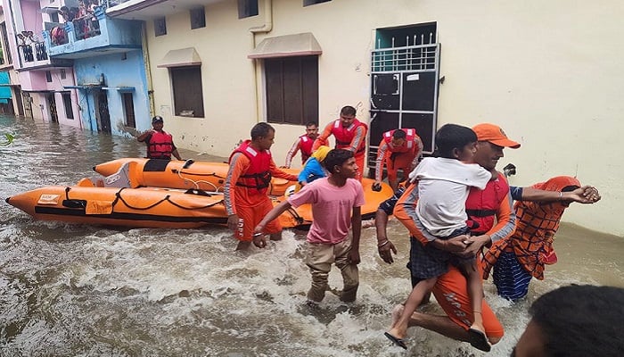 Members of National Disaster Response Force (NDRF) evacuate people to safer places from a flooded area in Udham Singh Nagar in the northern state of Uttarakhand, India, October 19, 2021. National Disaster Response Force/Handout via REUTERS