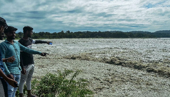 Locals point towards the risen water levels of the River Ganga after incessant rains in Indias Uttrakhand state. Photo: AFP