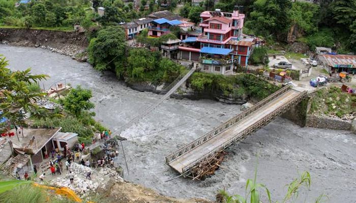 People gather near the bridge that is damaged due to the flood at Raghu Ganga River in Myagdi, Nepal July 11, 2020. — REUTERS/File