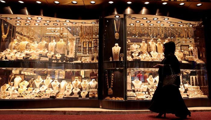 A woman walks past gold jewellery displayed in a shop window at the Gold Souq in Dubai, United Arab Emirates March 24, 2018. — Reuters/File