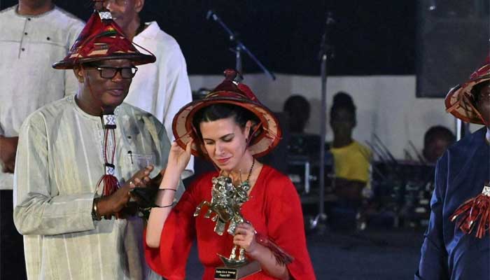 An unidentified woman receives the Golden Stallion of Yennenga trophy awarded to film director Khadar Ahmed of Somalia: AFP