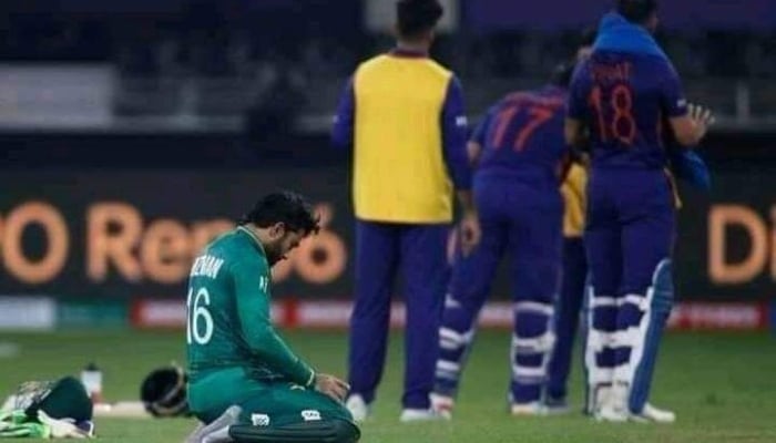 Rizwan prays as Indian cricketers chat in the background. Photo: Twitter