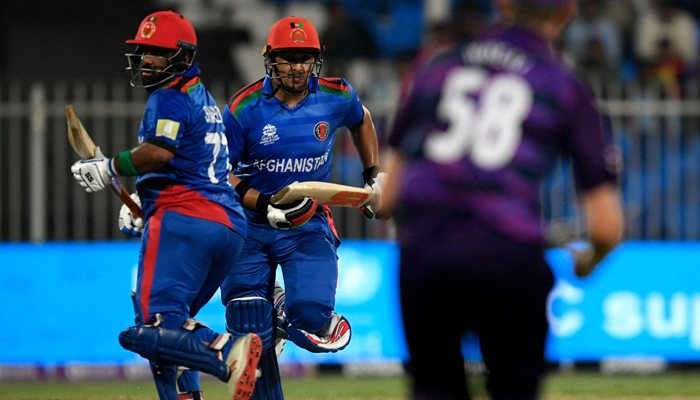 Afghanistan´s Mohammad Shahzad (L) and teammate Hazratullah Zazai run between the wickets during the ICC men’s Twenty20 World Cup cricket match between Afghanistan and Scotland at the Sharjah Cricket Stadium in Sharjah on October 25, 2021. — AFP