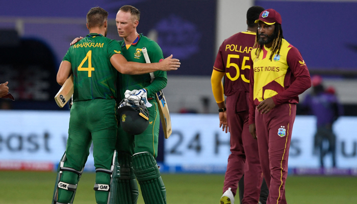 South Africa´s Aiden Markram (L) and Rassie van der Dussen celebrate their victory next to West Indies´ Chris Gayle (R) at the end of the during the ICC menâ€™s Twenty20 World Cup cricket match between South Africa and West Indies at the Dubai International Cricket Stadium in Dubai on October 26, 2021. — AFP
