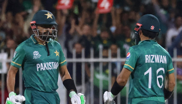 Pakistan´s captain Babar Azam (L) and Mohammad Rizwan talk during the ICC Twenty20 World Cup cricket match between Pakistan and New Zealand at the Sharjah Cricket Stadium in Sharjah on October 26, 2021. — AFP