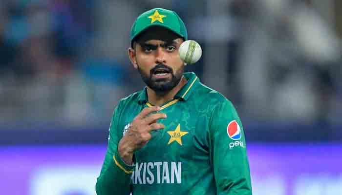 Pakistan´s captain Babar Azam passes the ball to a teammate during the ICC Mens Twenty20 World Cup cricket match between India and Pakistan at the Dubai International Cricket Stadium in Dubai on October 24, 2021.-AFP