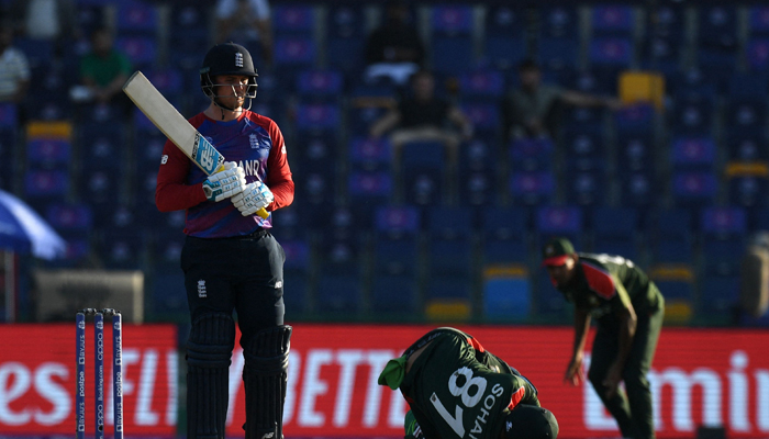 Bangladesh´s wicketkeeper Nurul Hasan (C) dives to stop the ball as England´s Jason Roy watches during the ICC menâ€™s Twenty20 World Cup cricket match between England and Bangladesh at the Sheikh Zayed Cricket Stadium in Abu Dhabi on October 27, 2021. — AFP