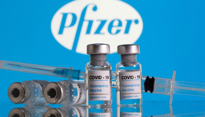 Vials labelled COVID-19 Coronavirus Vaccine and a syringe are seen in front of the Pfizer logo in this illustration taken February 9, 2021. — Reuters/File