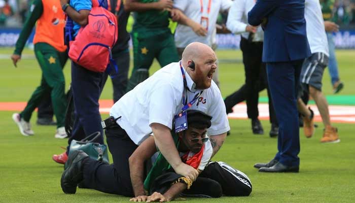 A security officer holds down an Afghan fan after the Pakistan-Afghanistan clash. Photo: AFP