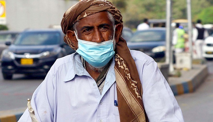Seorang pria memakai topeng untuk melindungi dirinya dari virus corona di Karachi. Foto: PPI