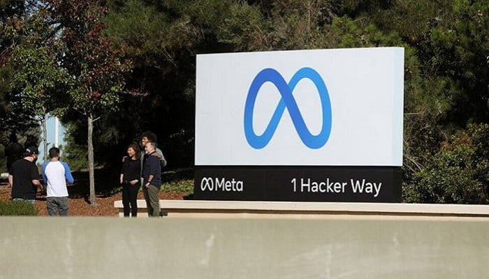 People pose for a photo in front of a sign of Meta, the new name for the company formerly known as Facebook, at its headquarters in Menlo Park, California, U.S. October 28, 2021. Photo: Reuters