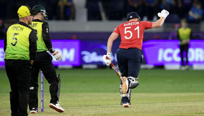 England´s Jonny Bairstow (R) celebrates his team´s win in the ICC Twenty20 World Cup cricket match between Australia and England at the Dubai International Cricket Stadium in Dubai on October 30, 2021. — AFP