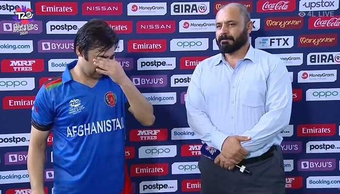 Asghar Afghan wipes a tear from his eye while speaking. Photo: Twitter