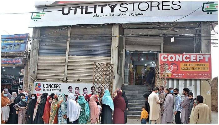 A large number of people standing in queues outside a Utility Store to purchase daily commodities during the Holy Month of Ramzan ul Mubarak. — APP/Ashraf Ch